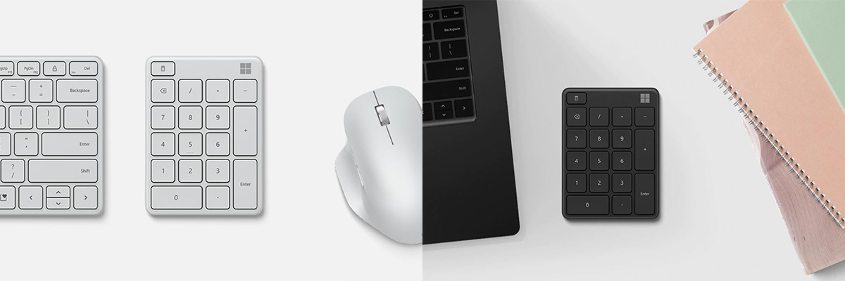 Das Microsoft Number Pad in Silber zwischen einer Tastatur und einer Maus und das Number Pad in Schwarz zwischen einem Surface Laptop und Notizblöcken