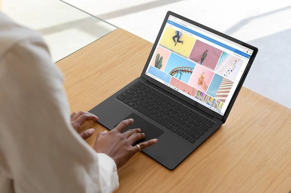 Eine Frau tippt auf das Trackpad des schwarzen Surface Laptop 3 