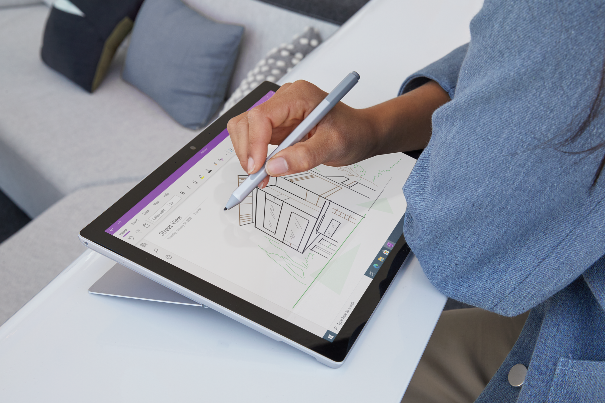 A person draws something on the Surface Pro 7 Plus in tablet mode with the Surface Pen in OneNote 