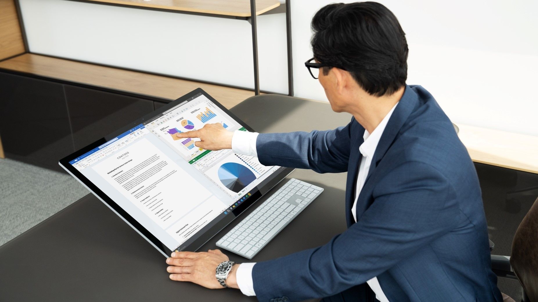 Man using Surface Studio 2+ touchscreen with 3 applications open simultaneously