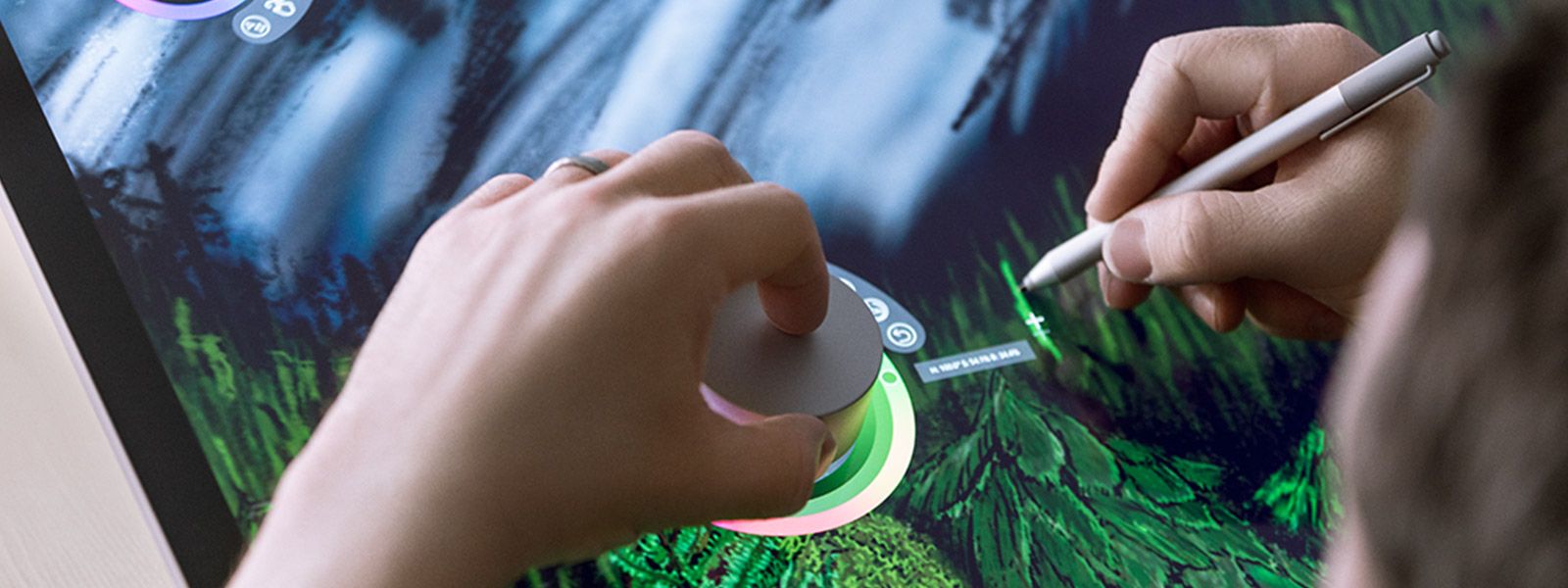 Close-up of man using the Surface Dial to change colors of a Surface Pen on a digital drawing